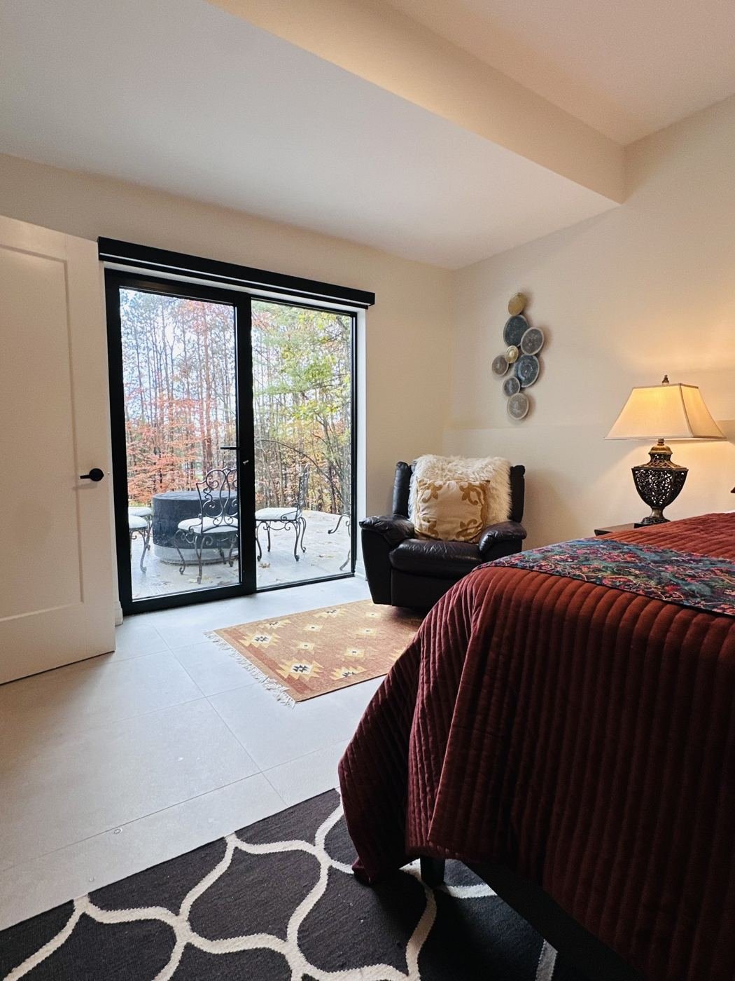 Bedroom corner with doors opening to the trees